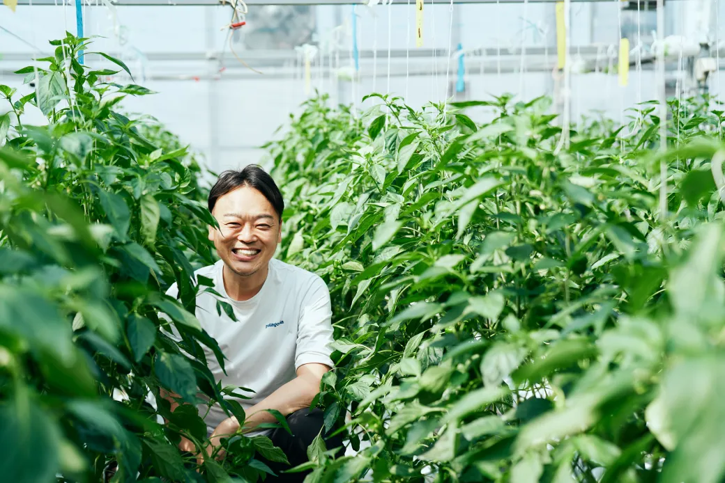 ビニールハウスの中で笑顔を見せるAGRIST株式会社 代表取締役 斎藤潤一氏