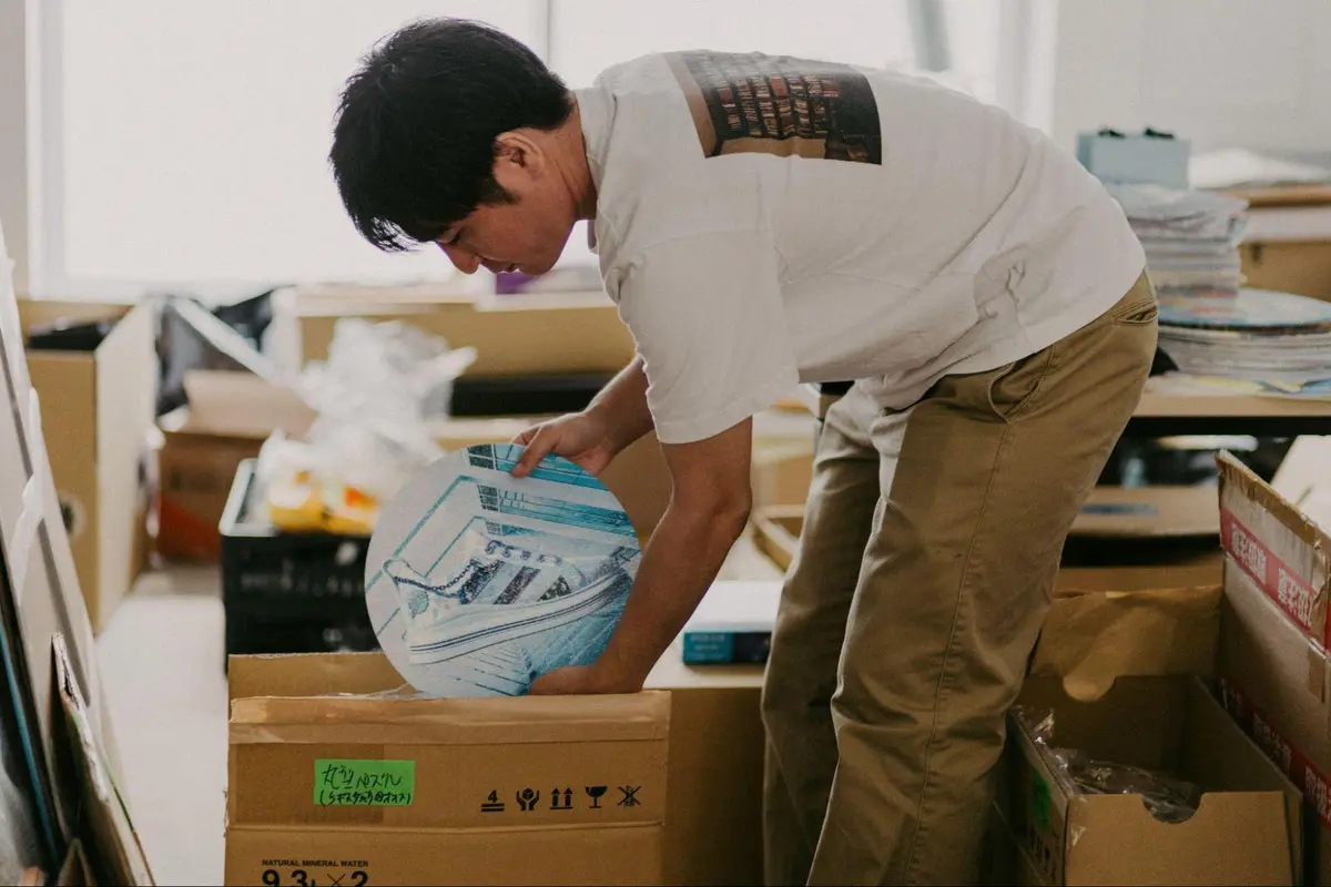 倉庫で梱包の作業をする小林英輔氏