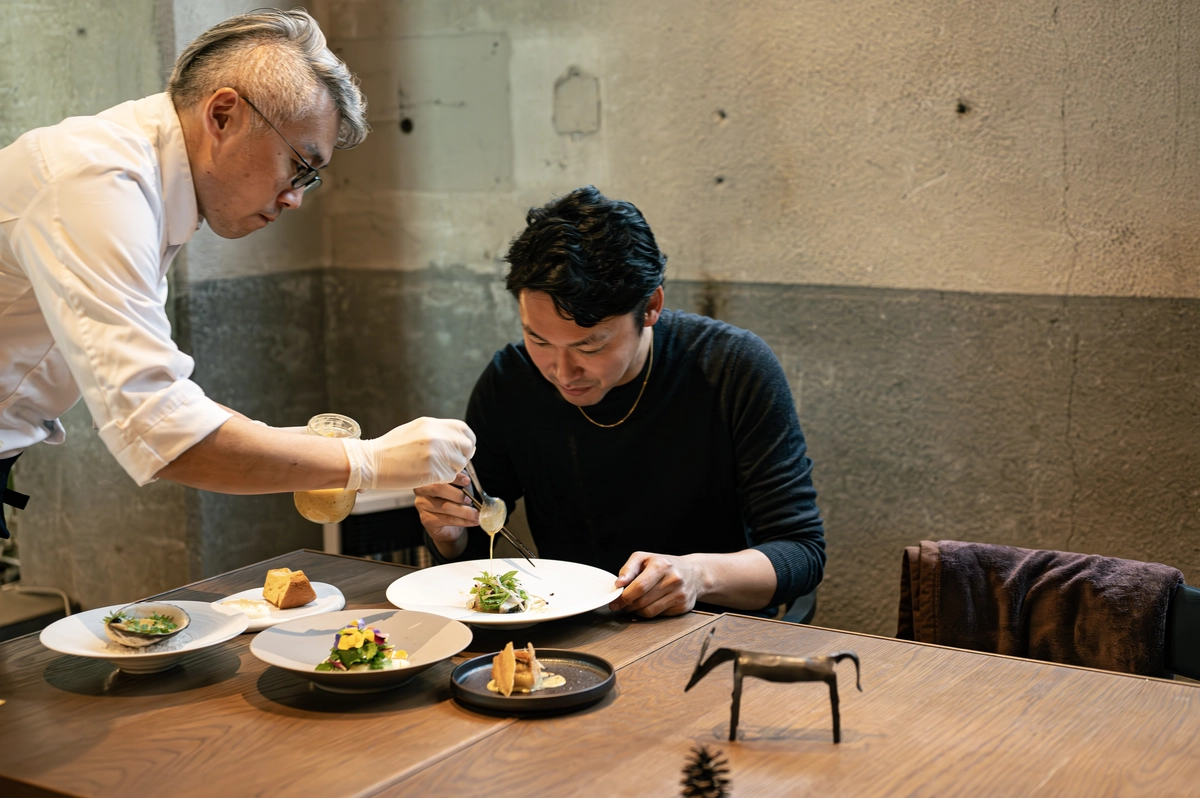 うま藻を使った料理を仕上げるシェフと髙田氏